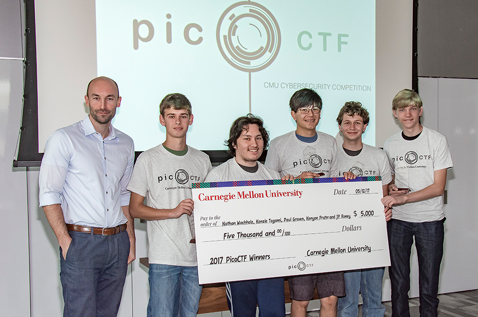 5 students holding large check for $5,000