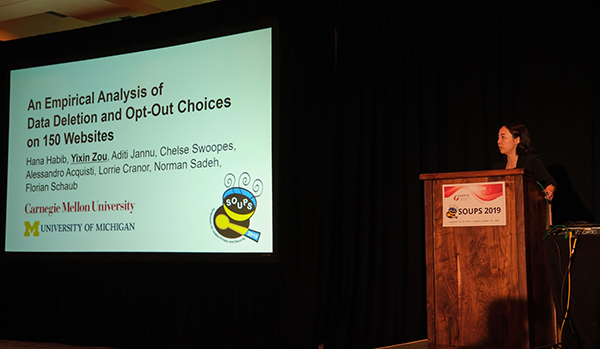 Woman standing at a podium next to a slide presentation
