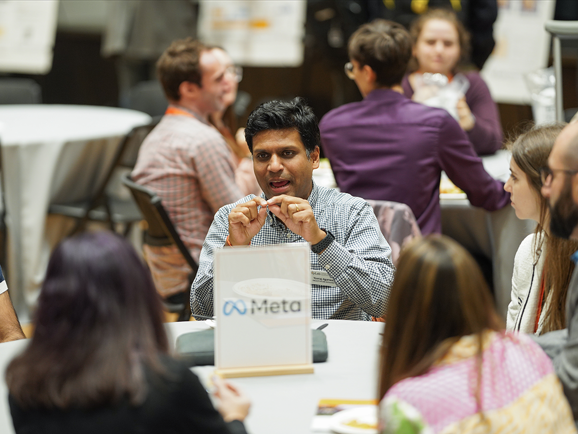 Photo of a group of people having a lunchtime conversation at the Meta partner table during the CyLab Partners Conference